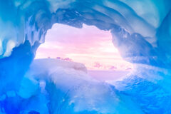 Blue,Ice,Cave,Covered,With,Snow,And,Flooded,With,Light