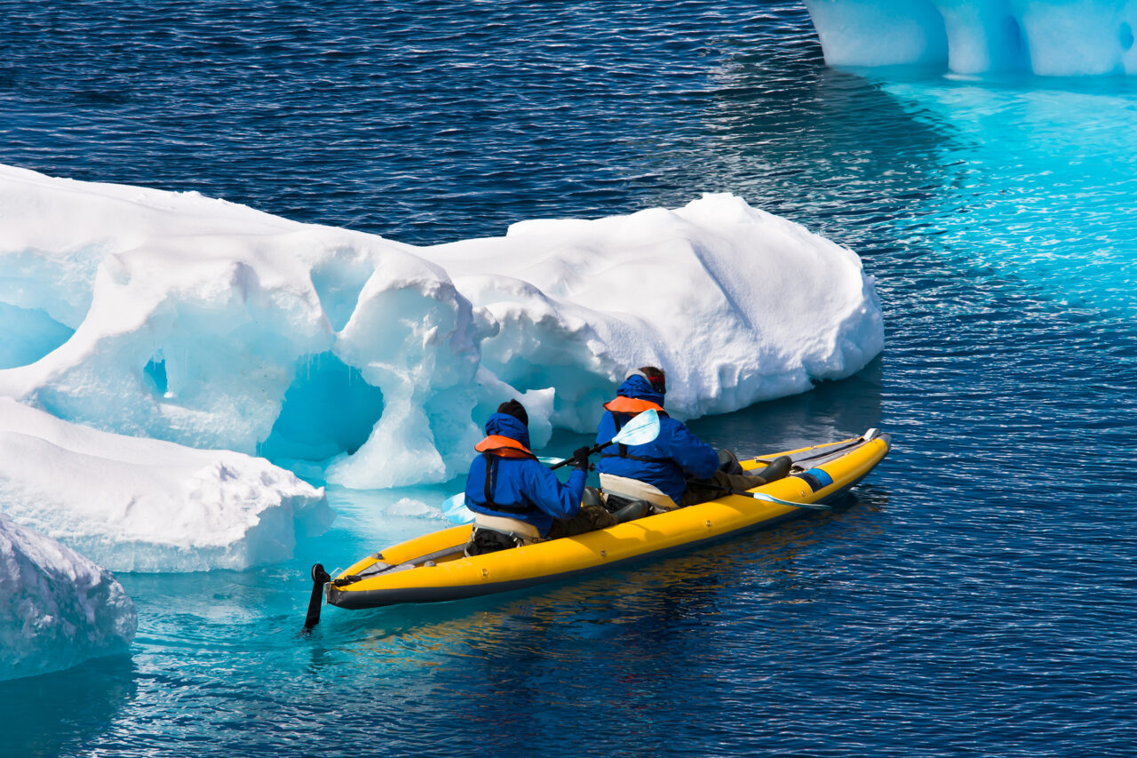 Two,Men,In,A,Canoe,Among,Icebergs,In,Antarctica